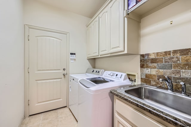 clothes washing area featuring sink, light tile patterned floors, cabinets, and independent washer and dryer