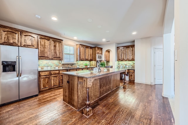 kitchen with backsplash, a center island, dark hardwood / wood-style flooring, and stainless steel appliances