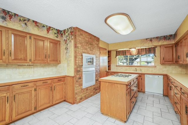 kitchen with a kitchen island, sink, a textured ceiling, and white appliances