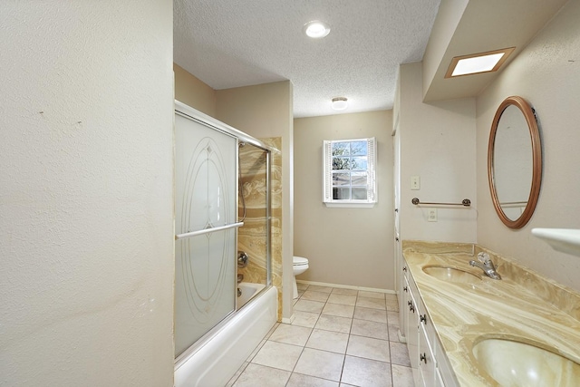 full bathroom with a skylight, bath / shower combo with glass door, vanity, a textured ceiling, and toilet