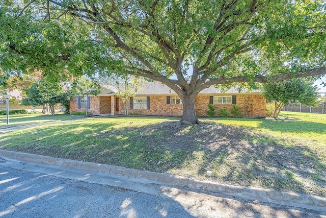 single story home featuring brick siding and a front yard