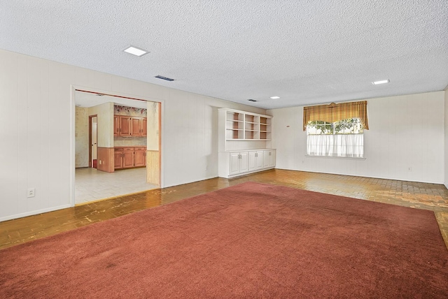 empty room featuring light carpet and a textured ceiling