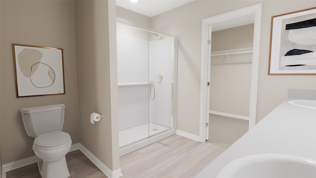 bathroom featuring hardwood / wood-style floors, vanity, toilet, and an enclosed shower