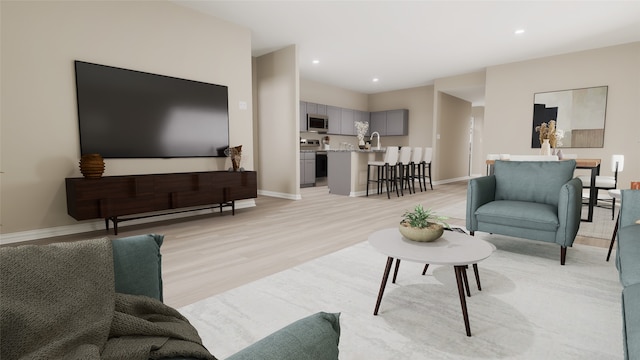 living room with sink and light hardwood / wood-style flooring