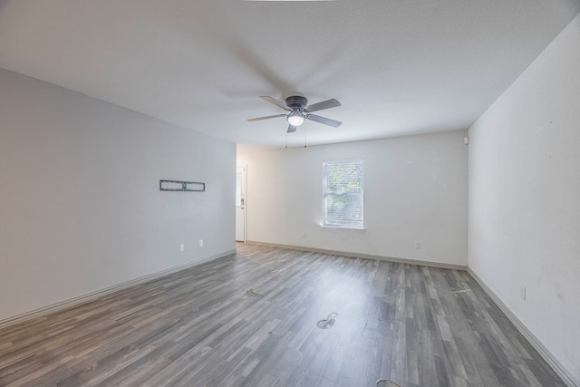 spare room featuring ceiling fan and dark wood-type flooring