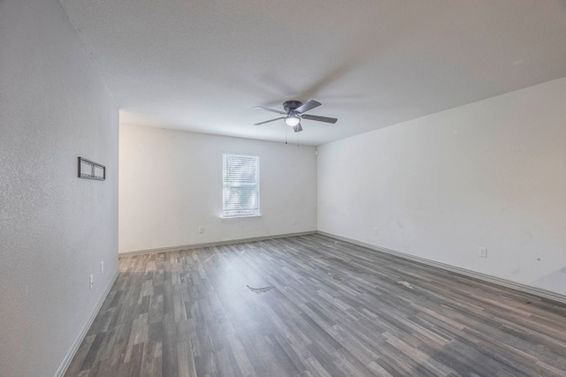 empty room featuring ceiling fan and dark hardwood / wood-style flooring