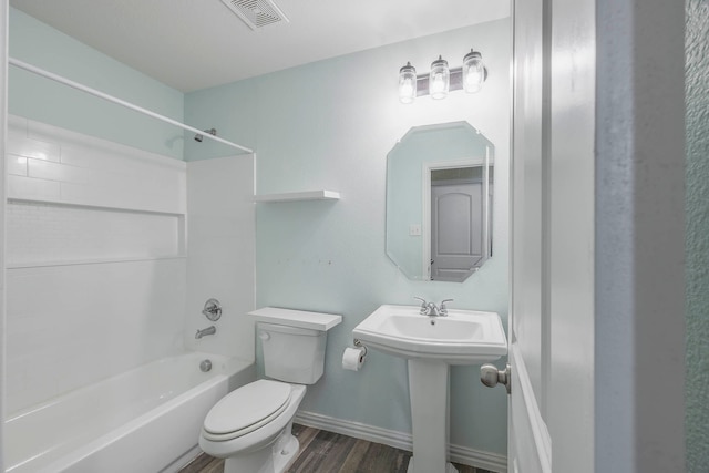 full bathroom with washtub / shower combination, hardwood / wood-style flooring, toilet, and sink