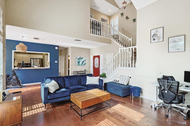 living room with a towering ceiling and hardwood / wood-style floors