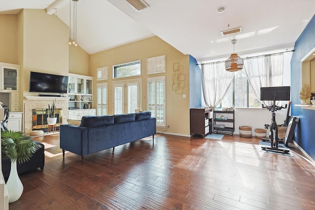 living room featuring hardwood / wood-style flooring, beam ceiling, and high vaulted ceiling