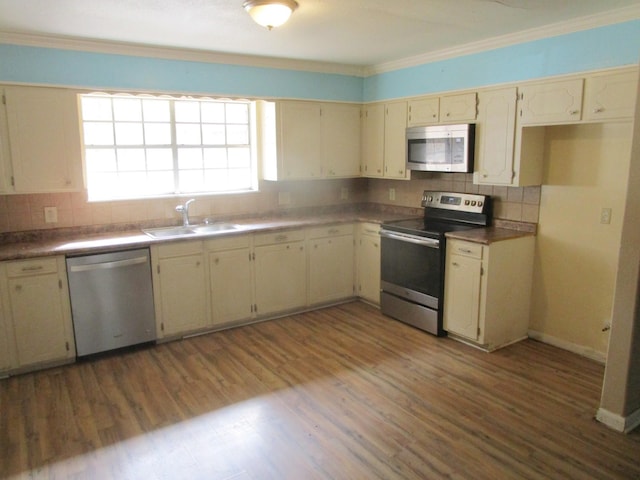 kitchen featuring cream cabinetry, stainless steel appliances, dark hardwood / wood-style floors, and sink