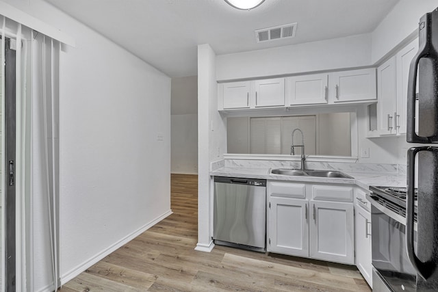 kitchen featuring white cabinetry, dishwasher, light wood-type flooring, and sink