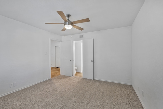 unfurnished bedroom with light colored carpet, ceiling fan, and ensuite bathroom