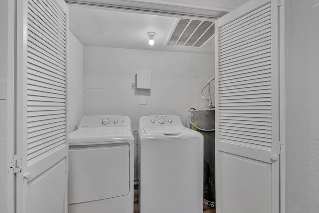 washroom featuring separate washer and dryer and a textured ceiling