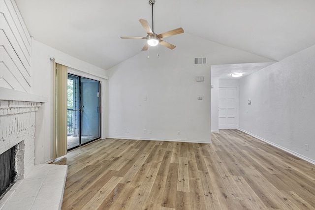 unfurnished living room with vaulted ceiling, a brick fireplace, ceiling fan, and light hardwood / wood-style flooring