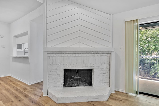 interior details with hardwood / wood-style flooring, sink, and a brick fireplace