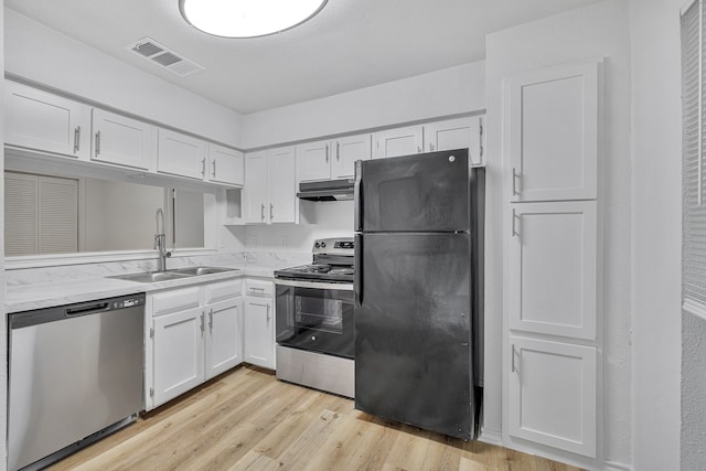 kitchen featuring stainless steel appliances, light hardwood / wood-style flooring, white cabinetry, and sink