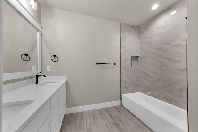 bathroom featuring vanity and tiled shower / bath