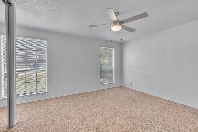 carpeted empty room with ceiling fan and a textured ceiling