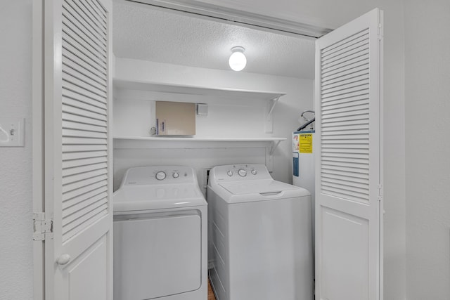 clothes washing area featuring washing machine and clothes dryer and a textured ceiling