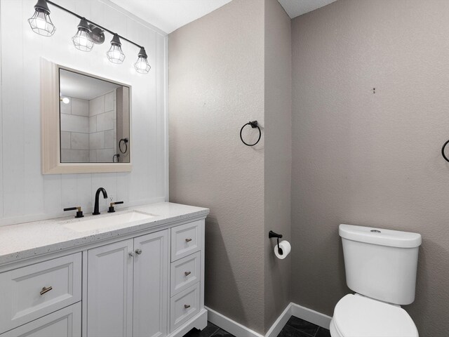 bathroom with tile patterned flooring, vanity, and toilet