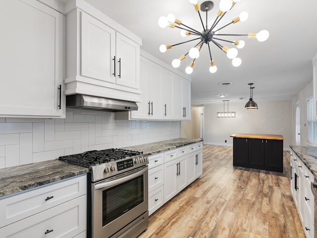 kitchen featuring white cabinetry, dark stone counters, stainless steel range with gas stovetop, decorative backsplash, and light wood-type flooring