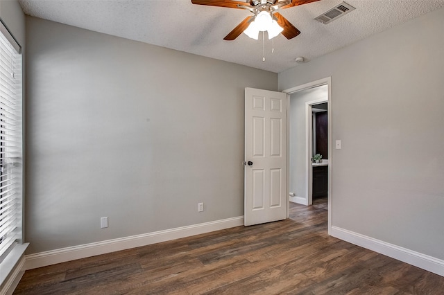 spare room featuring ceiling fan, dark hardwood / wood-style floors, and a textured ceiling