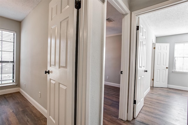 hallway with hardwood / wood-style flooring and a textured ceiling