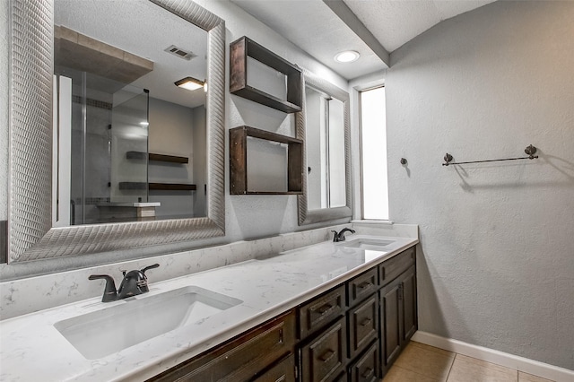 bathroom with tile patterned floors, vanity, a textured ceiling, a shower with door, and lofted ceiling