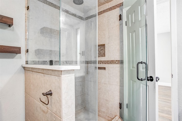 bathroom featuring hardwood / wood-style floors and a shower with shower door