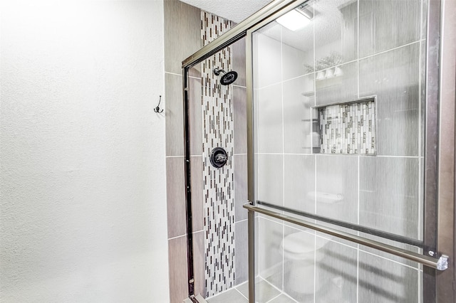 bathroom featuring a textured ceiling and walk in shower