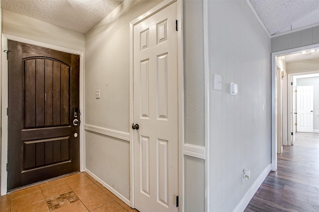 foyer entrance with light hardwood / wood-style floors and a textured ceiling