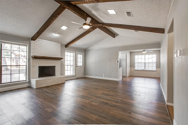 unfurnished living room with a fireplace, a textured ceiling, and dark hardwood / wood-style floors