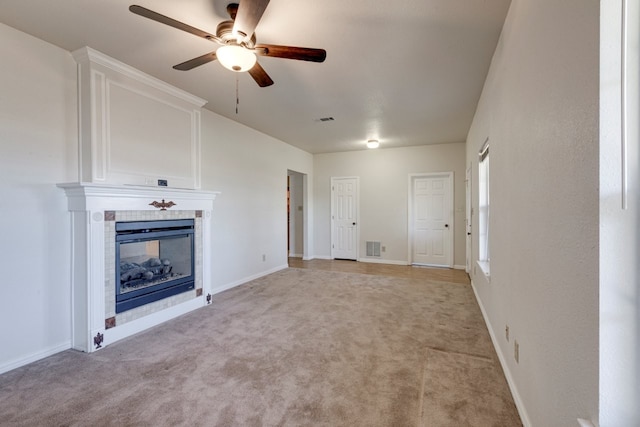 unfurnished living room with ceiling fan, light colored carpet, and a fireplace