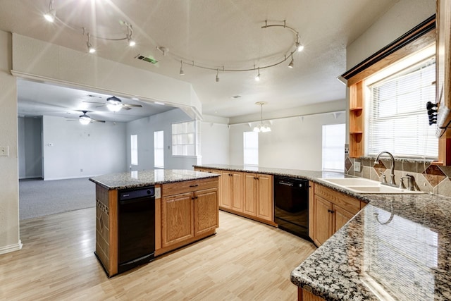 kitchen featuring sink, a center island, a healthy amount of sunlight, hanging light fixtures, and black dishwasher