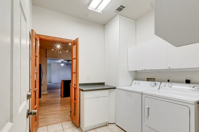 clothes washing area with cabinets, light hardwood / wood-style flooring, washer and dryer, and ceiling fan