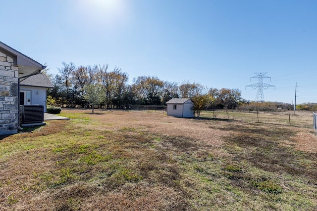 view of yard featuring a storage unit and central air condition unit