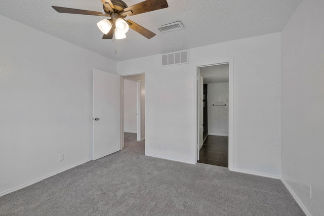 unfurnished bedroom featuring carpet, ceiling fan, a textured ceiling, and connected bathroom