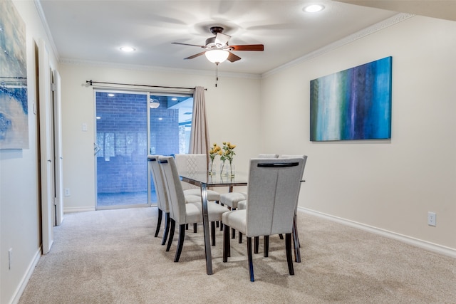 dining space with light carpet, ceiling fan, and ornamental molding