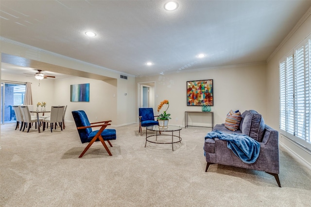 sitting room featuring light colored carpet, ceiling fan, and crown molding