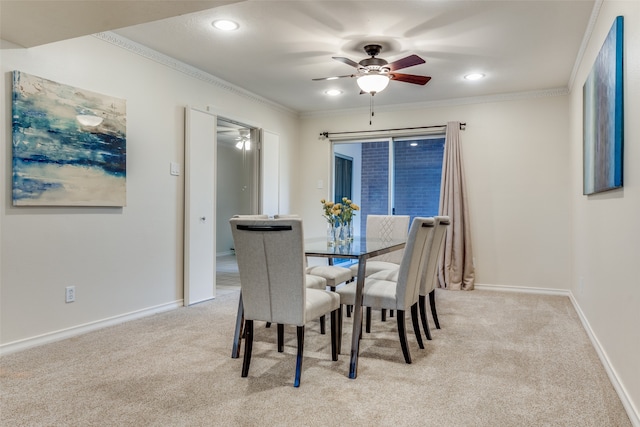 carpeted dining room with ceiling fan and ornamental molding