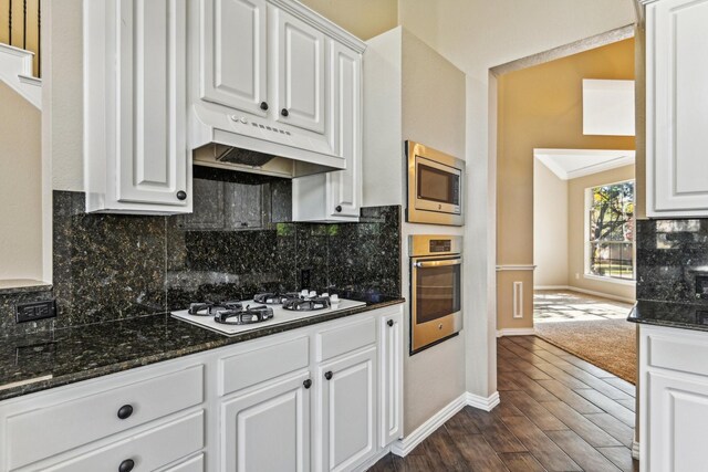 kitchen featuring tasteful backsplash, dark hardwood / wood-style flooring, white cabinets, and appliances with stainless steel finishes