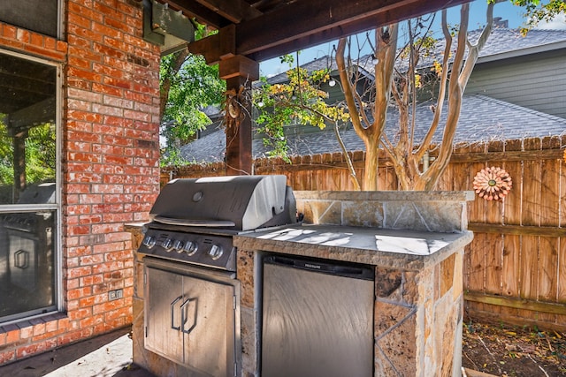 view of patio featuring an outdoor kitchen and a grill