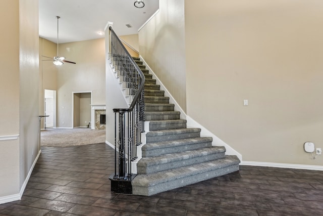 stairs featuring a high ceiling and ceiling fan