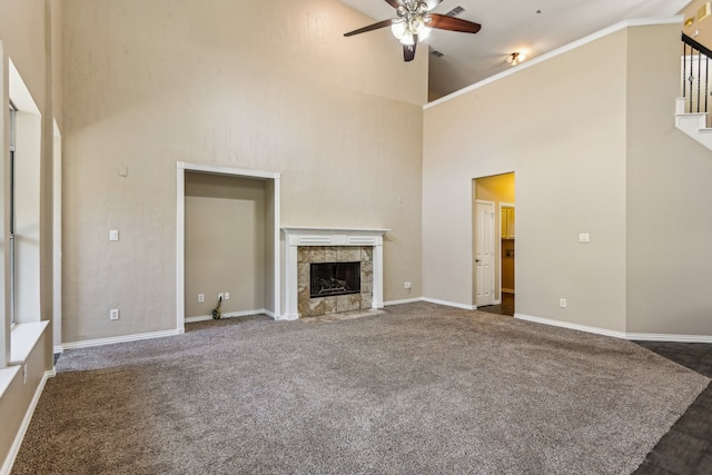 unfurnished living room featuring ceiling fan, dark carpet, a fireplace, and high vaulted ceiling