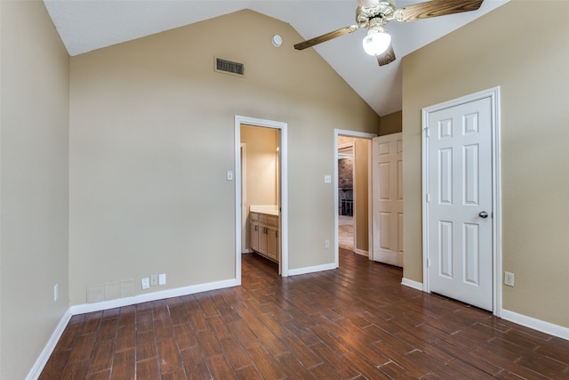 unfurnished bedroom with high vaulted ceiling, ensuite bath, ceiling fan, and dark wood-type flooring