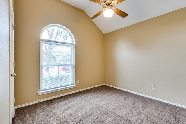 empty room with ceiling fan, carpet floors, and vaulted ceiling