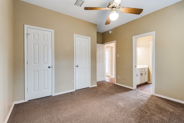 unfurnished bedroom featuring ensuite bathroom, carpet, and ceiling fan