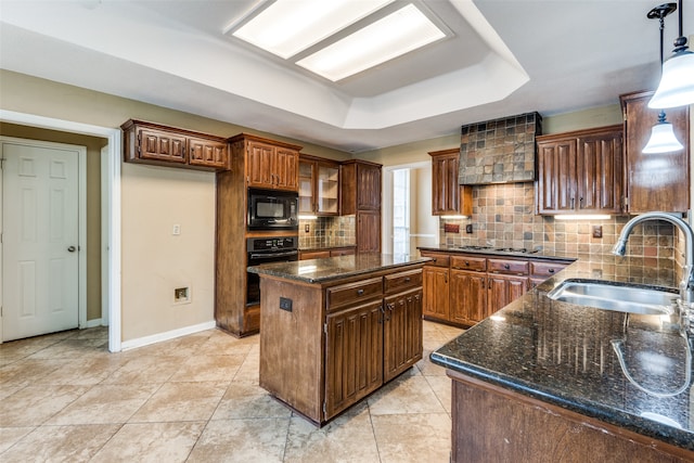 kitchen with decorative backsplash, black appliances, sink, pendant lighting, and a kitchen island