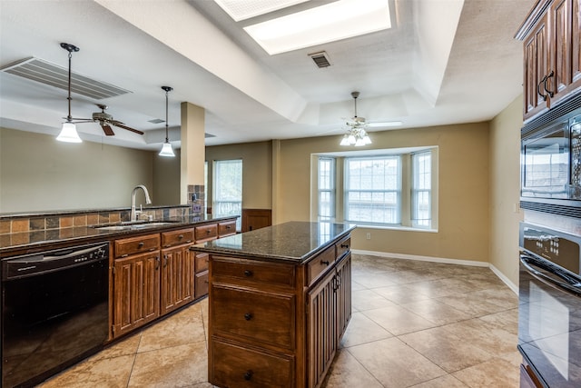 kitchen with sink, a center island, hanging light fixtures, a tray ceiling, and black appliances