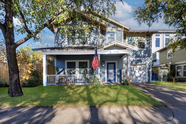 view of front of house featuring covered porch, a garage, and a front lawn